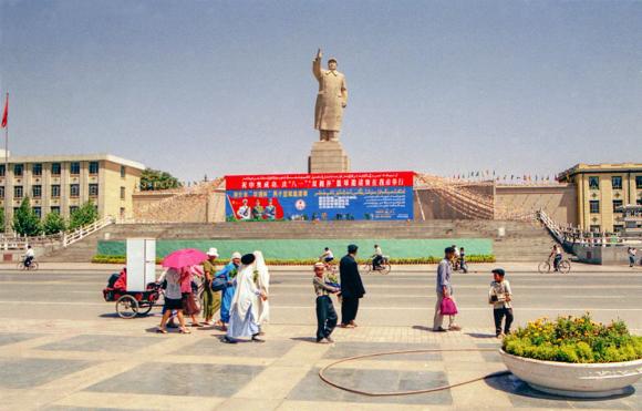 Zu sehen ist eine Statue in einem asiatischen Land. Die Statue ist von einem Mann der einen arm gehoben hat.