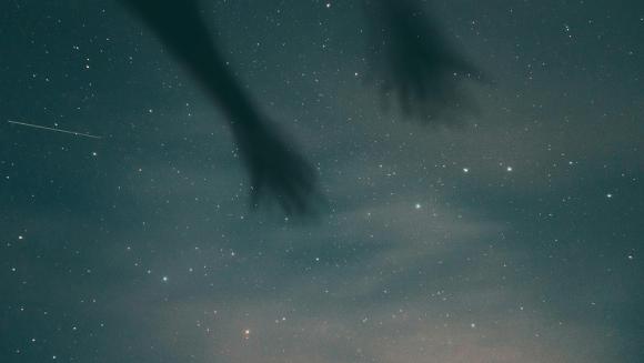 Zu sehen ist ein nächtlicher Sternenhimmel mit einer Sternschnuppe und den Schatten zweier Arme